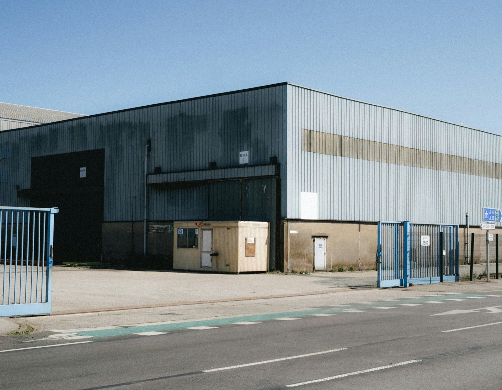 A single-storey industrial unit with roller gates and road access.